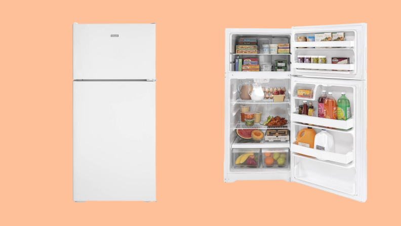 A top freezer fridge open over a peach background.