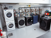 Several washer machines stacked on top of each other indoors.