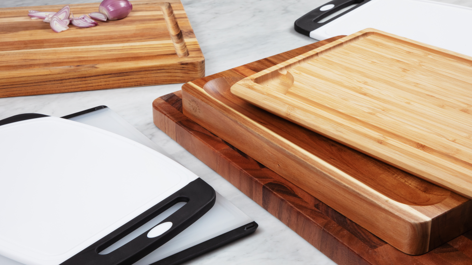 Stacks of wooden and plastic cutting boards on a marble surface