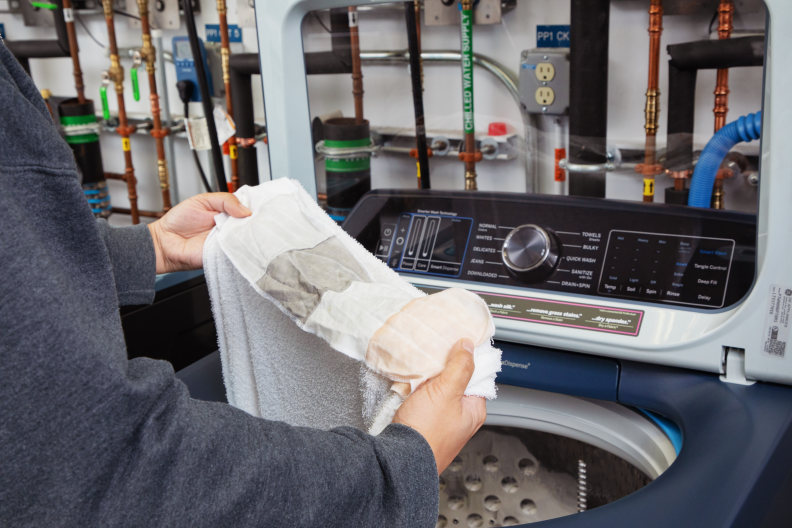 A man holds a stain strip that is wet and faded