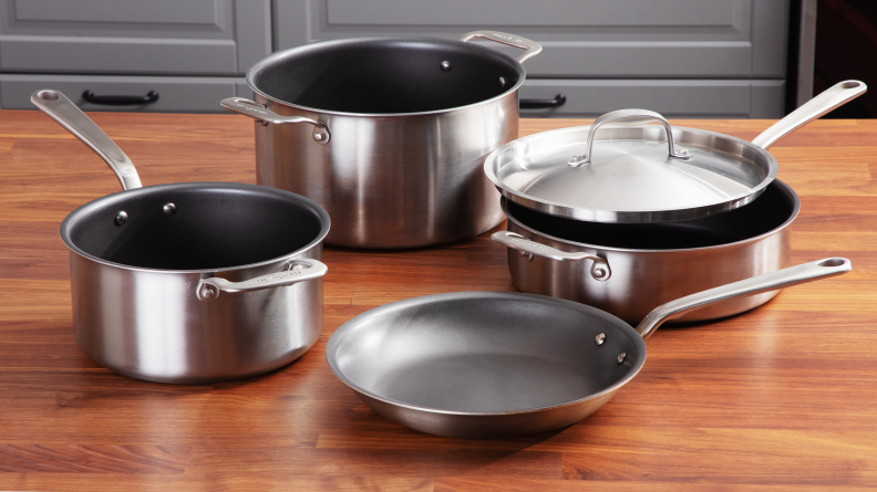 Four pieces of nonstick cookware on a wooden surface