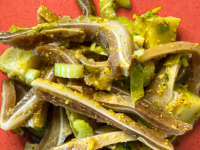 Pig ear potato salad on a red plate