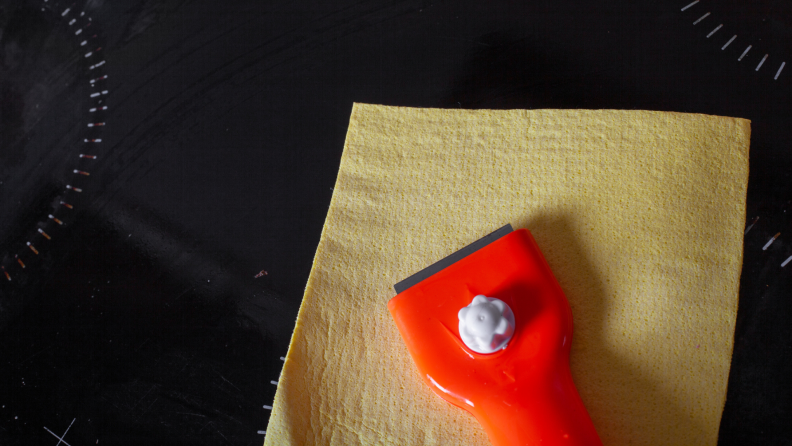 A razor blade tool sits on a stove top.